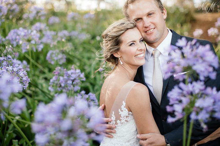 Wedding couple in the agapanthus at The Rose Barn