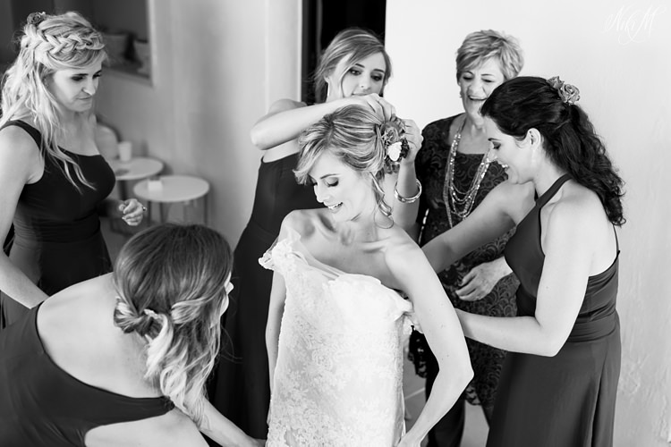 The bridesmaids help Tammy into her gown by Elizabeth Stockenstrom