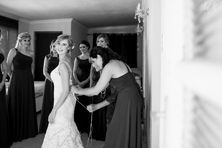 The bridesmaids help Tammy into her gown by Elizabeth Stockenstrom