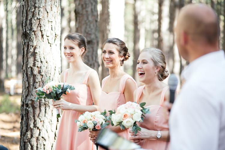 The bridesmaids laugh during the forest wedding ceremony