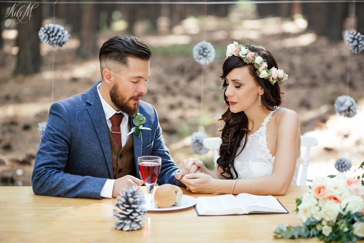 Amy and Silvino take their first communion as husband and wife with a pine cone backdrop