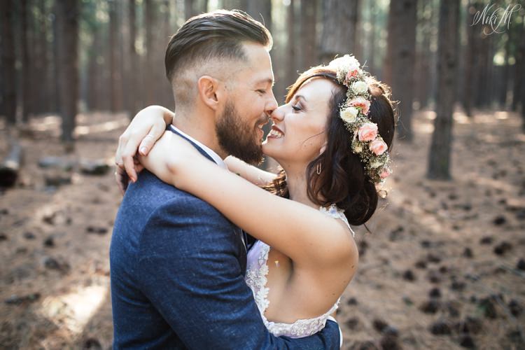 Stunning forest light envelopes the wedding couple as they hug