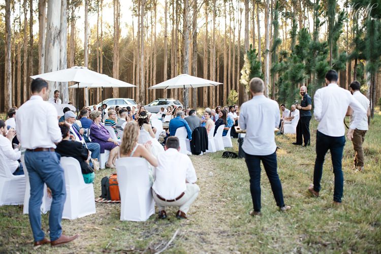 Guests listen to wedding speeches in the forest