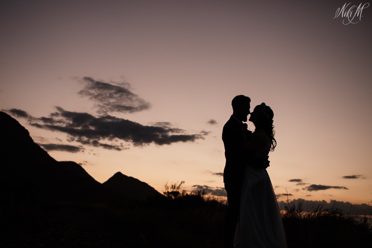 A sunset silhouette of the bridal couple