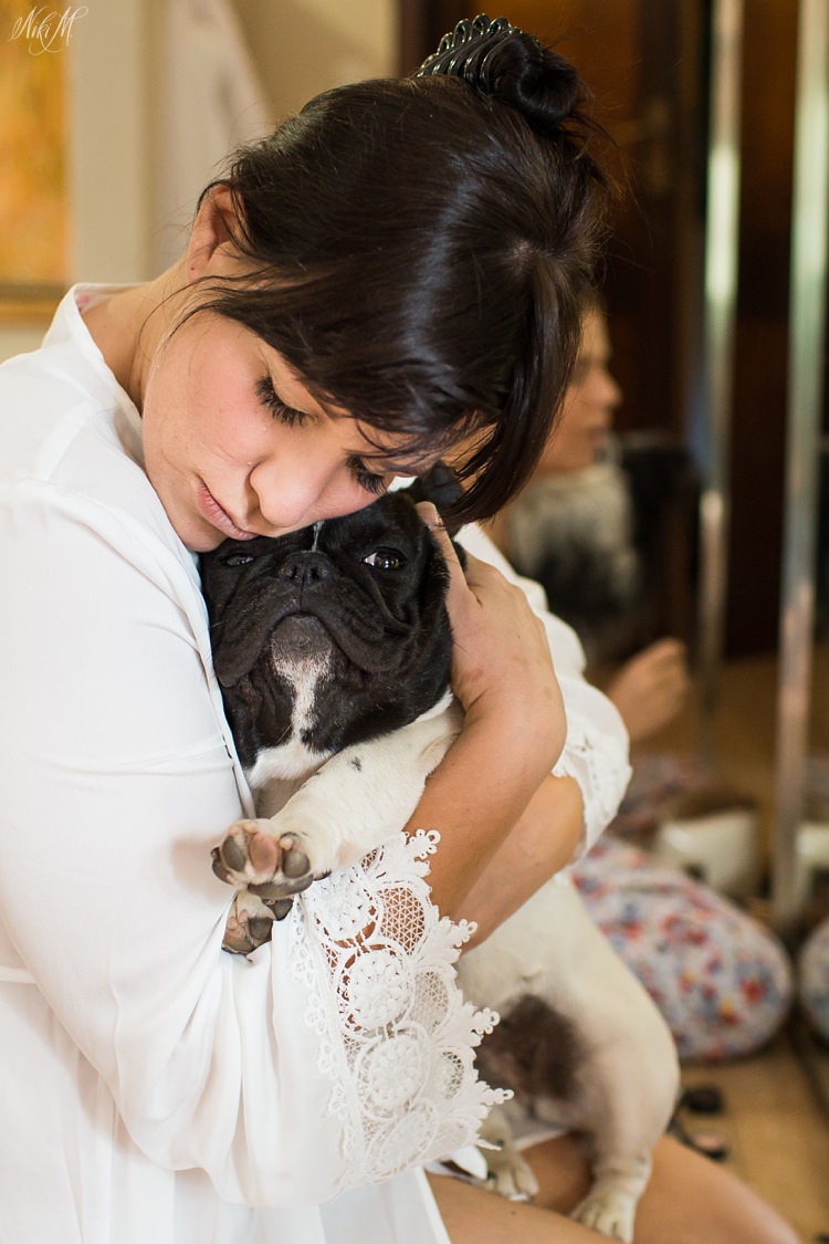Bride hugs her french bulldog whilst getting ready