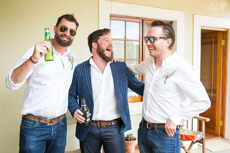 Groomsmen hold beers and laugh at Koedoeskloof Country Lodge in the Karoo