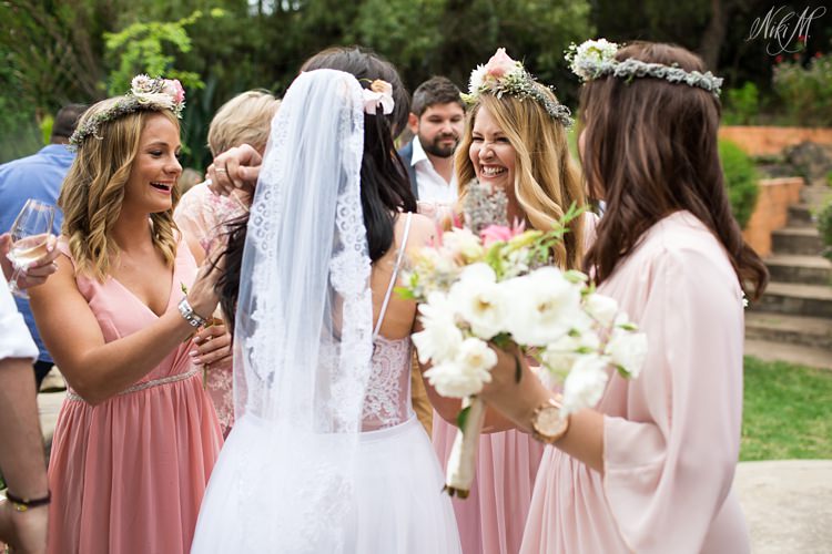 Bridesmaids wearing flower crowns celebrate with the bride after the wedding ceremony